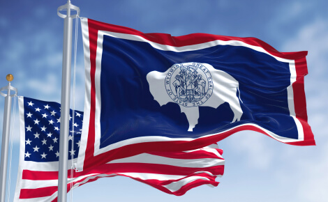 An American flag and the flag of the state of Wyoming.