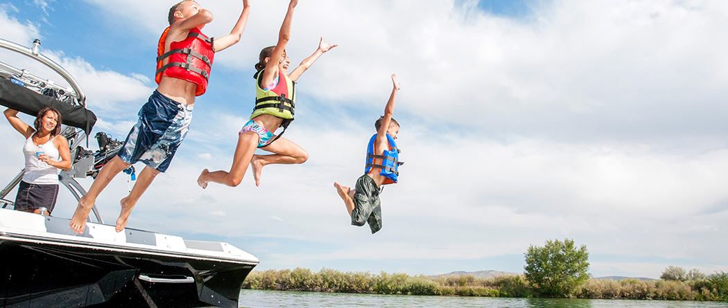 Family having fun jumping off a boat into water